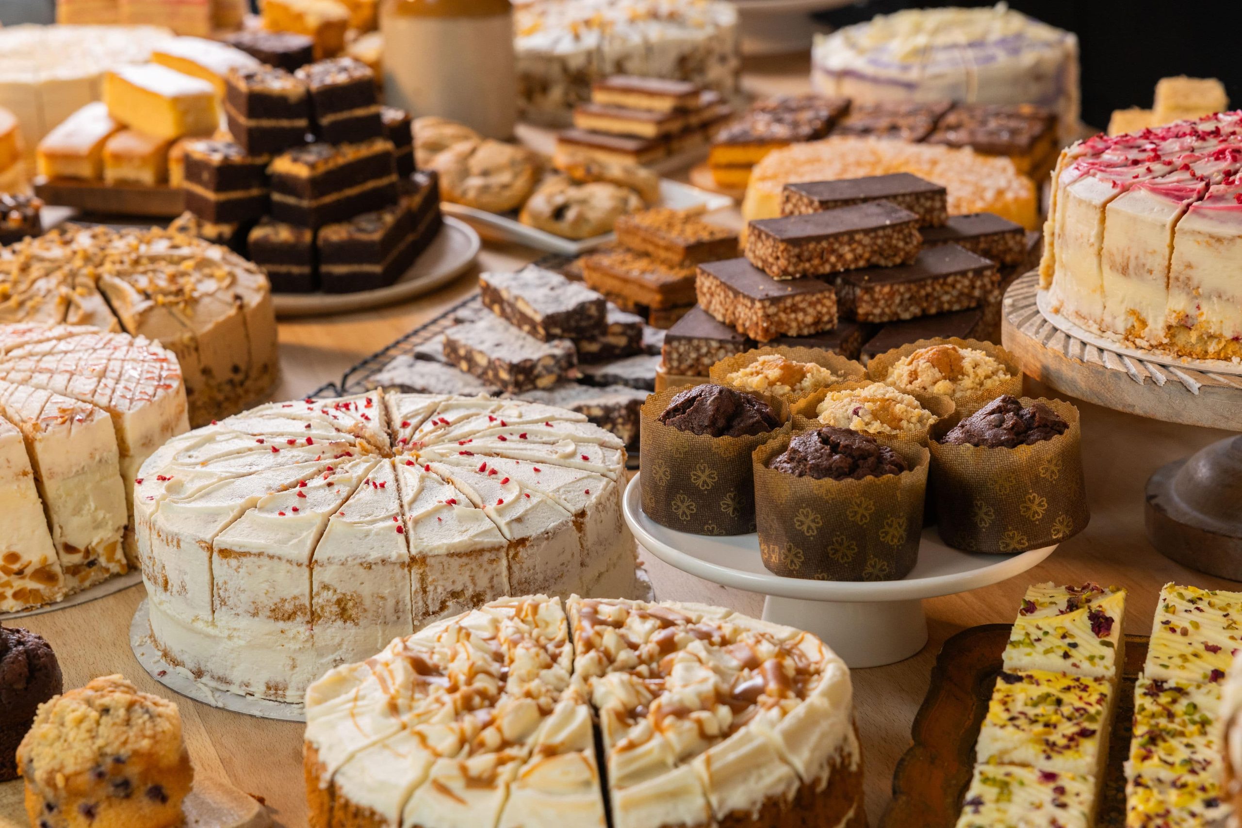 table covered in cake and muffins